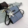 Μπλε τζιν και μαύρο δερμάτινο σακίδιο με ασημένιο αστέρι σε φόντο από λευκό ύφασμα - Με Μενταγιόν / Μαύρο