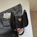 Sac hobo minimaliste en cuir noir avec logo triangle doré sur literie blanche - Sans Pendentif / Noir