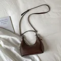 Close-up of deep brown woven leather hobo bag with adjustable strap and silver hardware - Brown