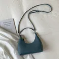 Detail of blue woven texture handbag with silver hardware and adjustable strap on white fabric - Iceland Blue