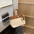Bolso tote de lona y cuero marrón con colgante de cuentas de madera y remaches - Con Colgante de Cuentas de Madera / Marrón