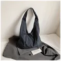 Borsa hobo a quadri blu e neri con dettaglio fiocco su sfondo di un abito grigio - Nero