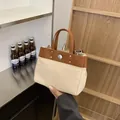 Bolso tote de lona con detalles de cuero marrón y asas dobles en un entorno cotidiano - Sin colgante / Marrón