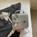 Fashionable silver hand-held crossbody bag with star and balloon dog charms on a suit background - Rhinestone Pattern With Pendant