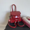 Detail of red glossy mini backpack featuring polished PU leather and cherry charms - Red with Pendant