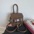 Detailed view of brown retro backpack with drawstring, flap logo, and cherry pendant - Coffee with Pendant