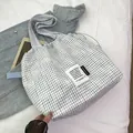 Blue and white checkered drawstring tote bag with rustic fabric texture and side label - White Large
