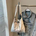 Off-white canvas drawstring crossbody bag with red C'mulaidie embroidery detail - With Charm / Off White