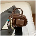 Retro brown gloss Boston bag with dual front flap pockets and candy charm accessory - Brown with Pendant