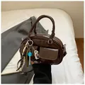 Trendy dark brown glossy baguette bag with cute cartoon pendants and double front pockets - Coffee with Pendant