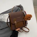 Vintage brown and tan leather backpack with a plush bear charm and adjustable straps - With Charm / Coffee