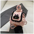 Pink mini backpack with lace trim, red bow patterns and a black plush cat head motif - Pink