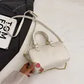 Borsa Boston bianco crema con trama litchi, graziosi ciondoli a fragola e catena dorata - Bianco