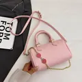 Borsa a bauletto cilindrica in pelle rosa con ciondolo a fragola e catena dorata - Rosa