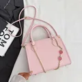 Borsa a spalla rosa con trama litchi, catene dorate e ciondoli a forma di fragola - Rosa