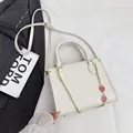 Borsa beige in pelle martellata con elegante catena dorata e ciondolo a fragola - Bianco