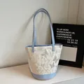 Cream bucket tote bag featuring grey butterfly patterns and light blue contrast handles - Blue
