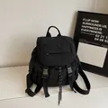 Minimalist black nylon sports backpack with adjustable buckles and drawstring detail - Black