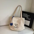 Crème canvas draagtas met zwarte letters en een marineblauwe mini-opbergzakje als bedeltje - Off-wit