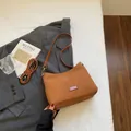 Brown matte suede hobo bag with adjustable strap and silver hardware on white bedding - No Pendant / Brown
