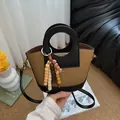 Khaki canvas emmer tas met zwarte lederen bekleding en kleurrijke kralenkwastje - Karamel Met Bedel