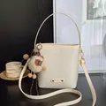 Sac seau minimaliste blanc crème en cuir texturé avec un charmant pendentif en peluche - Blanc Cassé Avec Pendentif