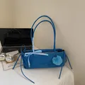 Blue rectangular shoulder bag with plaid bow and fuzzy pom-pom in a lifestyle setting - Blue with Pendant