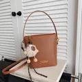 Sac seau chic en cuir marron à texture litchi avec un joli charm d'alpaga en peluche - Marron avec Pendentif