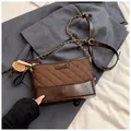 Borsa a secchiello trapuntata marrone scuro con catena dorata e materiali misti - Con Ciondolo / Marrone