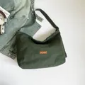 Borsa a tracolla a mezzaluna in tela verde scuro con etichetta in pelle e zip - Verde