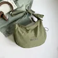 Hellgrüne halbmondförmige Umhängetasche aus Nylon mit Faltenoptik und breitem Gurt - Grün