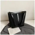 Minimalistische schwarze Beuteltasche aus mattem Texturmix und Leder mit Goldbeschlägen - Schwarz