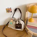 Off-white canvas drawstring bucket bag with woven leather handle and charms - Small / Beige