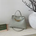 Detail of light green woven leather bucket bag with signature gold knot hardware - Green