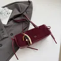 Burgundy faux suede baguette underarm bag with decorative side ties and beaded charm - With Pendant / Red