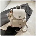 Chic beige lychee textured leather mini backpack with silver twist locks and bear charm - With Charm / Off White