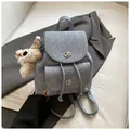 Light blue denim vintage backpack with a white plush dog charm and metal turn locks - With Charm / Denim Blue