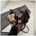 Dark brown leather half-moon underarm bag with silver buckle and plush bear charm - Coffee With Pendant