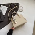 Elegant beige woven structured crossbody bag with adjustable strap and classic ribbon - Off White