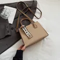 Khaki woven square bag with brown leather straps and decorative logo ribbon detail - Khaki