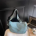 Light blue nylon crossbody bag with dual diagonal zippers and adjustable wide strap - Blue