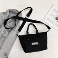 Minimalist black nylon crossbody square bag with adjustable strap and dual rope handles - Black