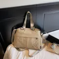 Detailed close-up of large khaki nylon handbag showing soft texture and logo - Khaki