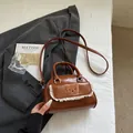Schultertasche in Retro-Braun mit Plüschbär und Spitze vor minimalistischem Hintergrund - Braun
