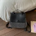 Women's black backpack featuring silver rivet studs and a sleek leather flap cover - Black