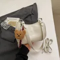 Creamy white vintage underarm bag with plush bear charm and embossed lettering - Style With Plush Bear Pendant / White