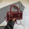 Fashionable burgundy square handbag with patchwork leather texture and top handle - Burgundy