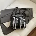 Schwarzer Lederrucksack mit grauen Karotaschen und weißen Spitzen-Schleifen-Akzenten - Schwarz