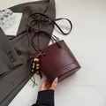 Bolso cubo burdeos retro con textura de cuero trenzado y elegante colgante de madera - Con Colgante / Rojo