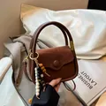 Brown vintage suede crossbody bag with decorative wooden beads and wavy flap design - Brown